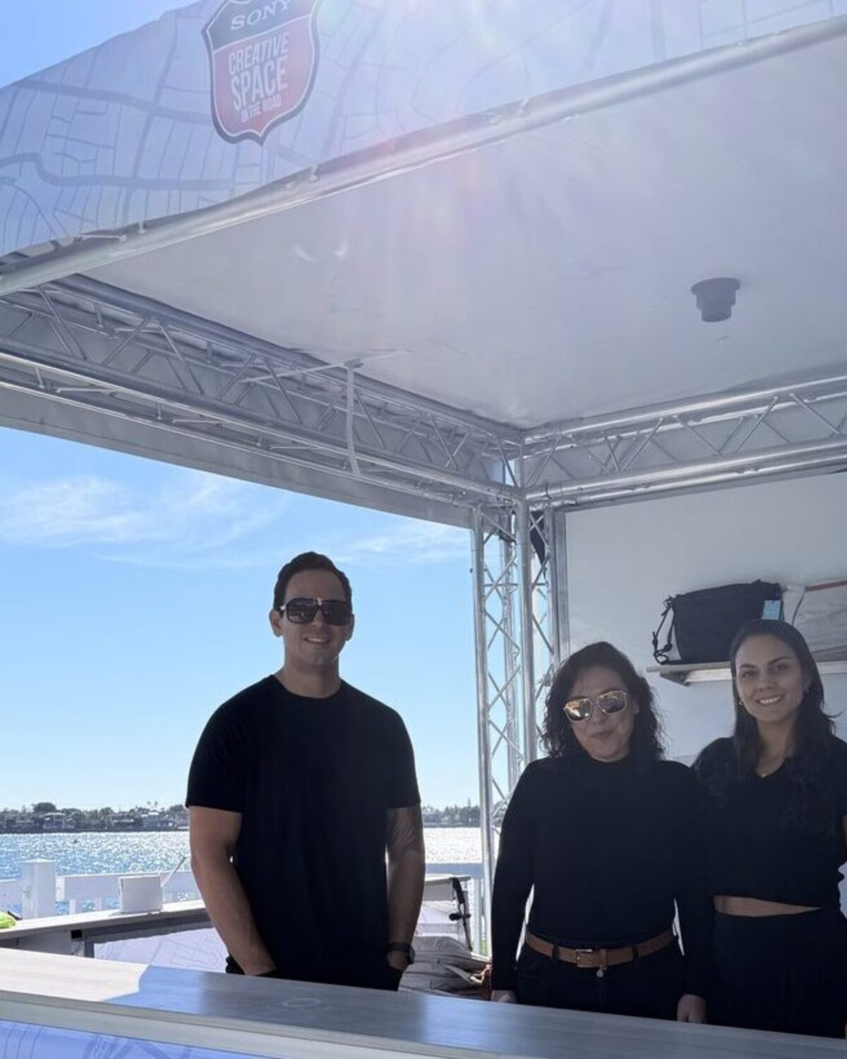 Merch Troop crew staffing a truss-frame customization booth on the waterfront